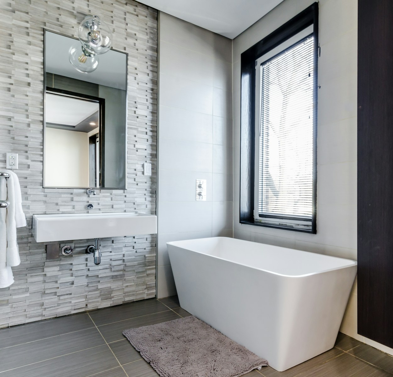 white ceramic bathtub near white framed window Bathroom Breeding Grounds