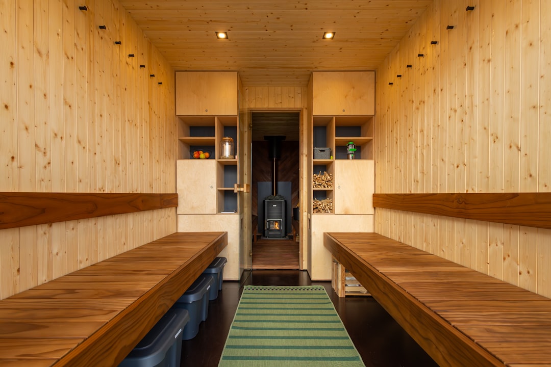 a long row of wooden benches sitting next to each other - Infrared Saunas