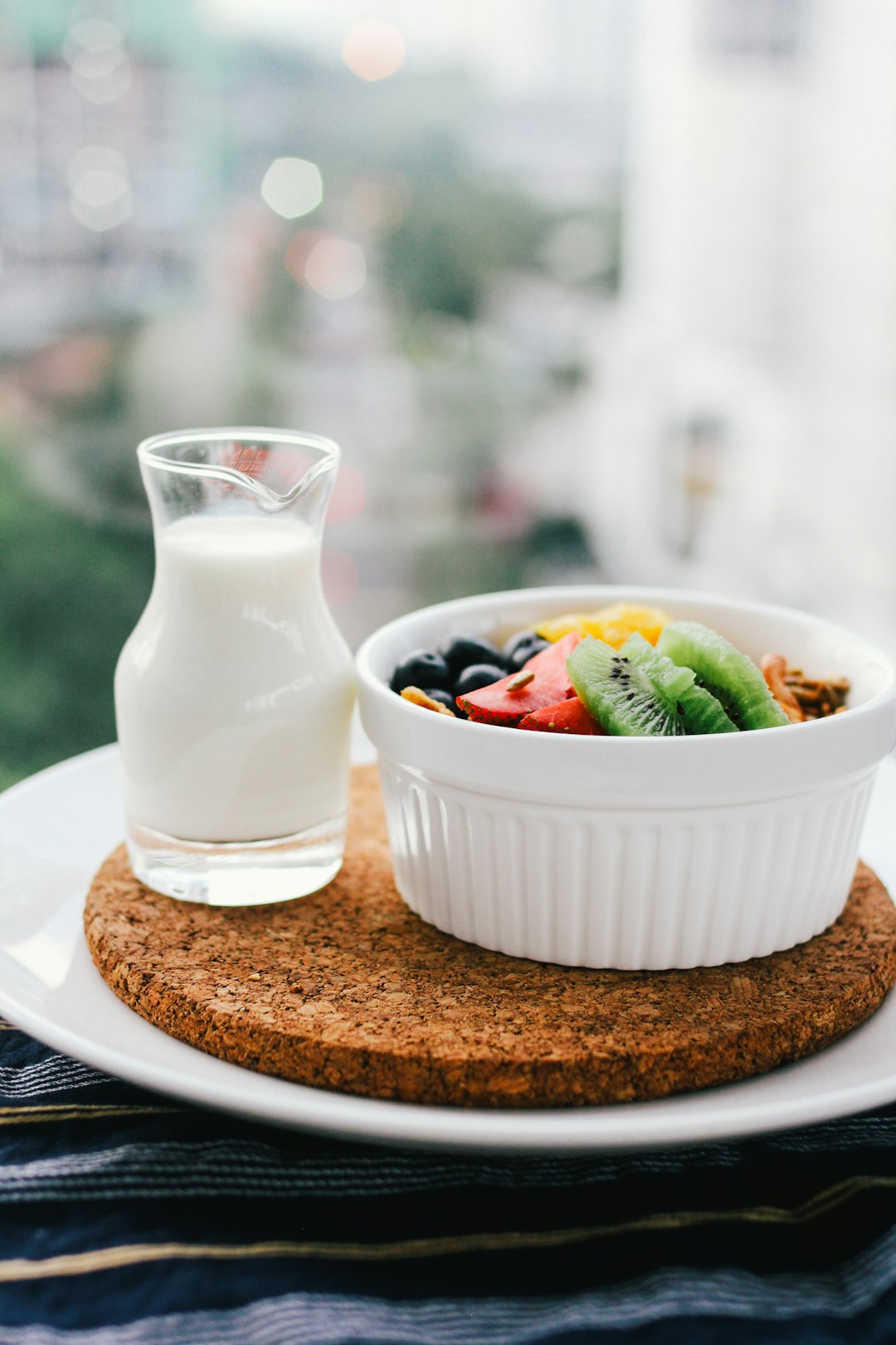 fruit salad inside bowl beside glass of milk on brown board - Inflammation-Mental Health Connection