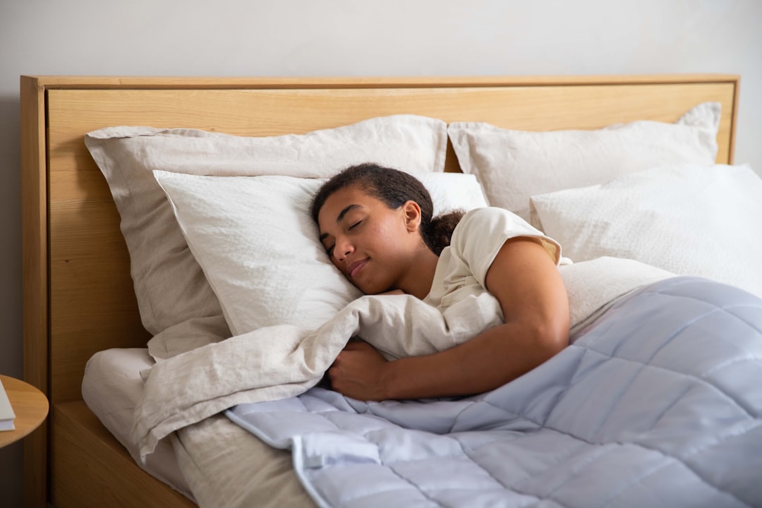 a young girl sleeping in a bed with white sheets- Quality Sleep