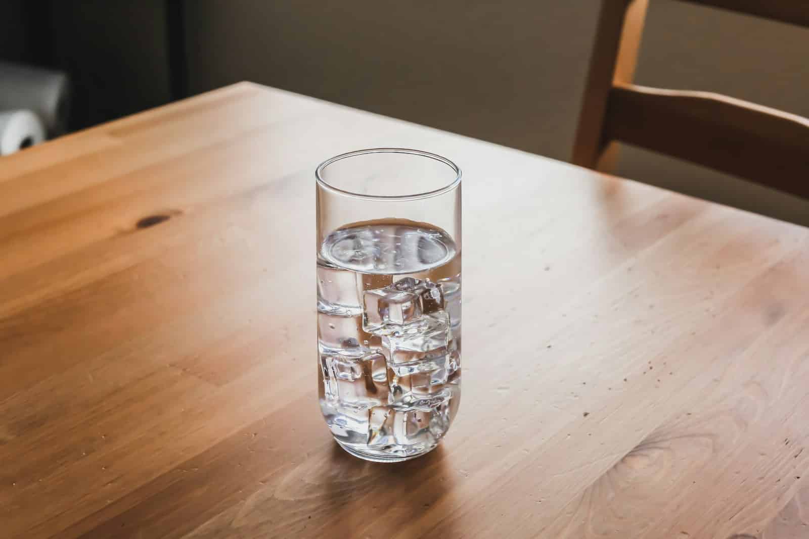 clear drinking glass on brown wooden table - Water Matters