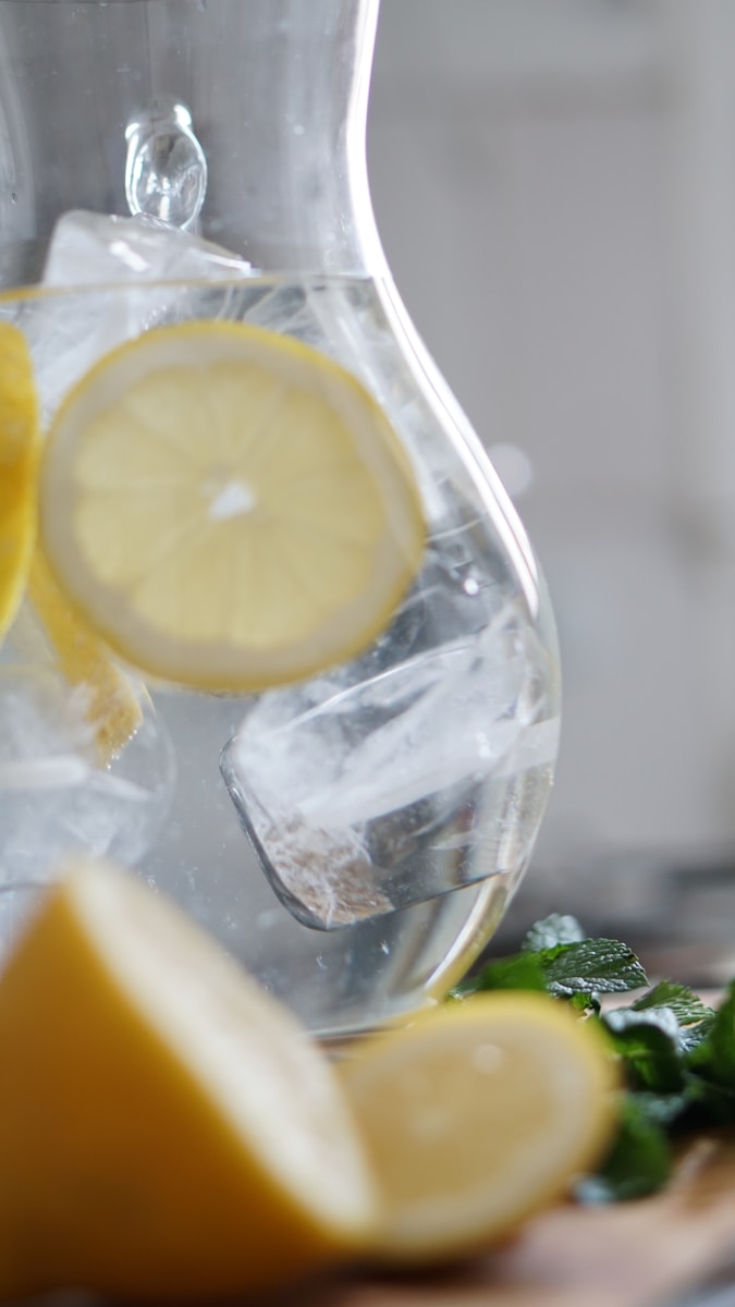 sliced lemon inside pitcher with ice cubes Drink Abundant Water