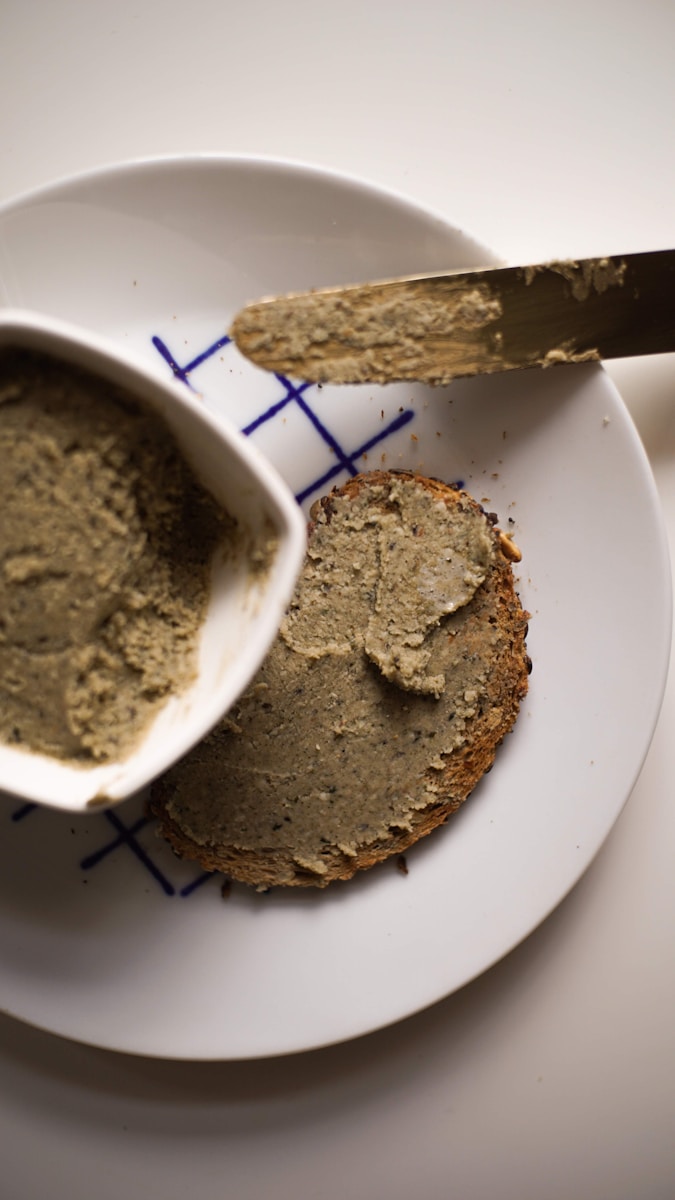 a white plate topped with a piece of bread and a bowl of peanut butter Omega-3 and Brain Health