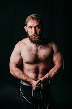 Focused male athlete with a beard displaying muscular build and