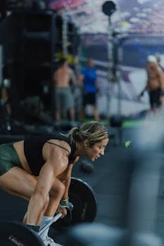 Athletic woman lifting weights in a gym, showcasing strength and focus.