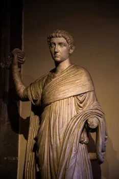 Classical Roman statue in soft lighting, showcasing detailed drapery and