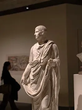 Ancient Roman statue on display in a Beijing museum with a visitor in the