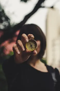 A woman extending a compass towards the camera, creating a focus on