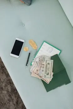Flat lay of money, phone, and notebook on a mint sofa. Perfect for finance