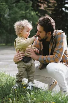 A father and his young son share a playful moment outdoors, emphasizing