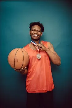 Basketball player holding a ball and medal representing achievement