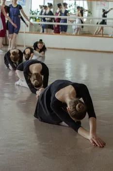 A group of ballerinas stretching in a dance studio, reflecting dedication