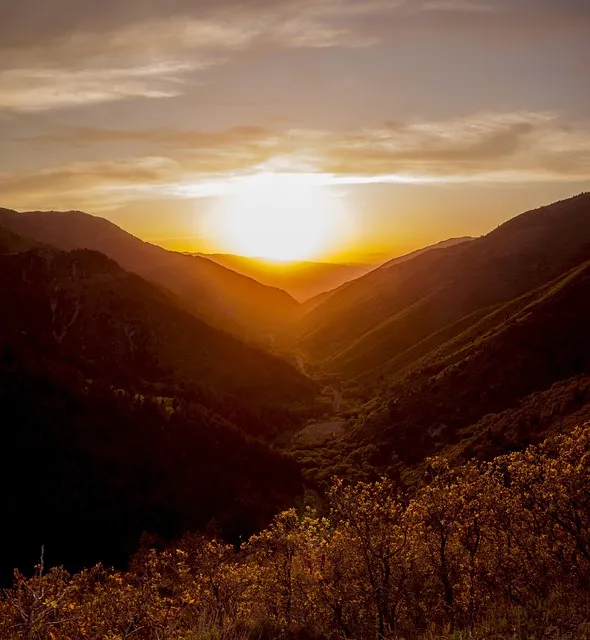 man hiking mountain peak at sunrise