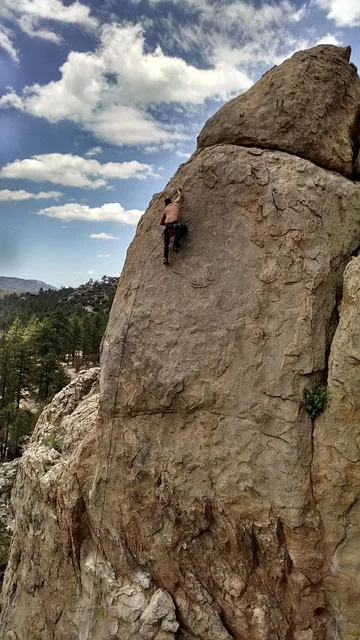 rock climber ascending a steep summit face, extreme challenge, perseverance