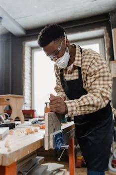A craftsman focused on woodworking in a well-equipped workshop, creating