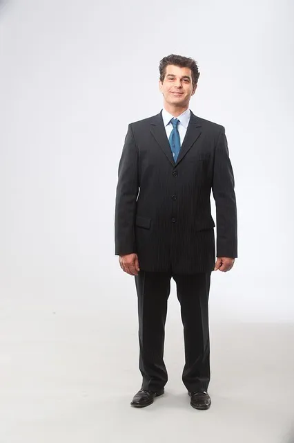 businessman standing at a window overlooking city, confident posture,