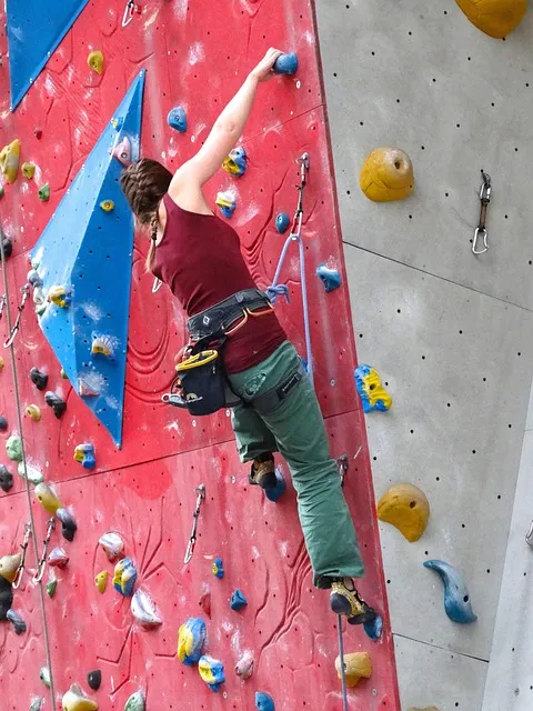 climber on rock face, arms straining, determination, resilience through