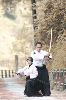 Two martial artists practicing with katanas