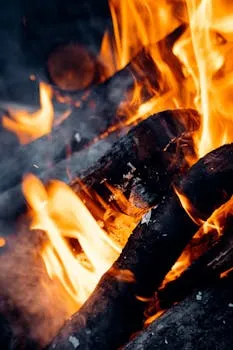 Intense close-up of burning firewood with bright flames in a vertical