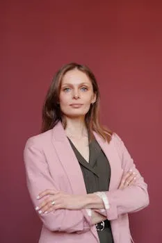 Elegant businesswoman with arms crossed in studio portrait, showcasing