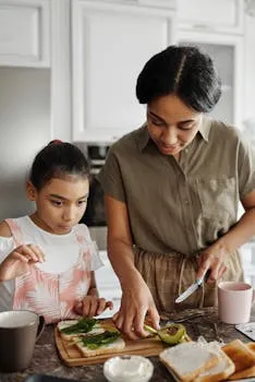 A woman and her daughter preparing a healthy breakfast with vegetables and
