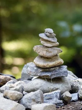 Close-up of a balanced stone cairn in a natural outdoor setting, symbolizing