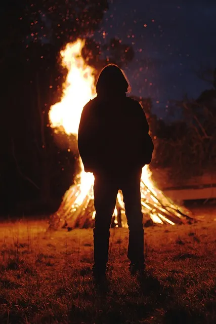 Silhouette by a bonfire at night symbolizing a ritual of letting go of