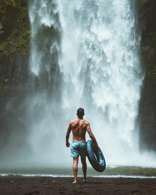 Man immersed in a natural waterfall practicing cold water grounding exercises