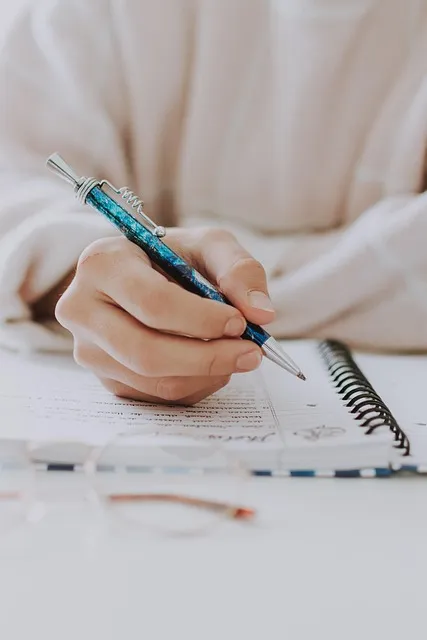 Hand writing in a gratitude journal as part of a daily abundance and