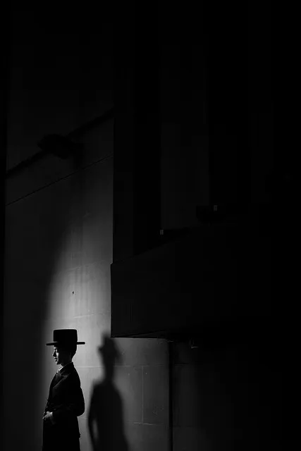 Person sitting alone in darkness representing the isolation of untreated