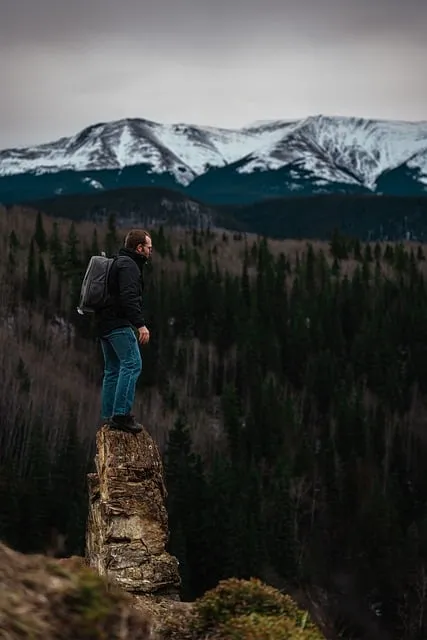 Man standing at mountain peak at sunrise experiencing the effects of silence