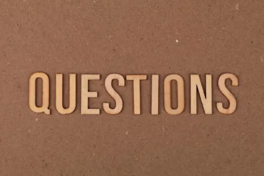 Wooden letters spelling the word QUESTIONS on a cardboard background,