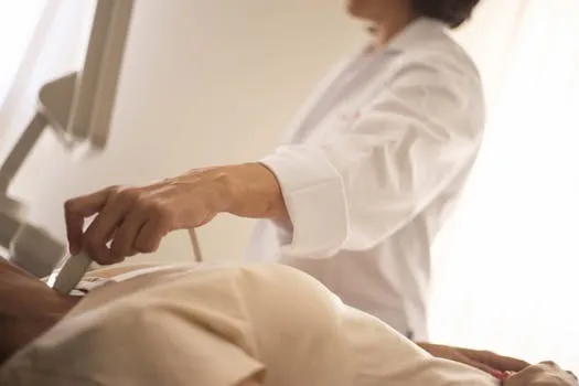 A medical professional conducts an ultrasound on a patient in a clinical