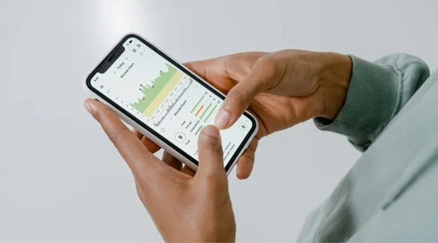 Close-up of hands holding a smartphone showing a health tracking app with