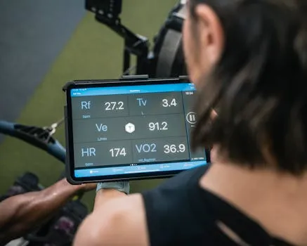 Adult man reviewing fitness metrics on a tablet during a workout session at