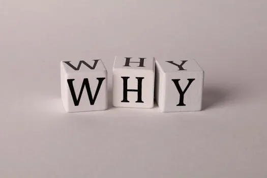 Close-up of lettered dice spelling WHY on a neutral background, ideal for