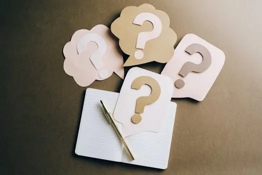 Flat lay of question mark paper crafts on a notebook, symbolizing questions